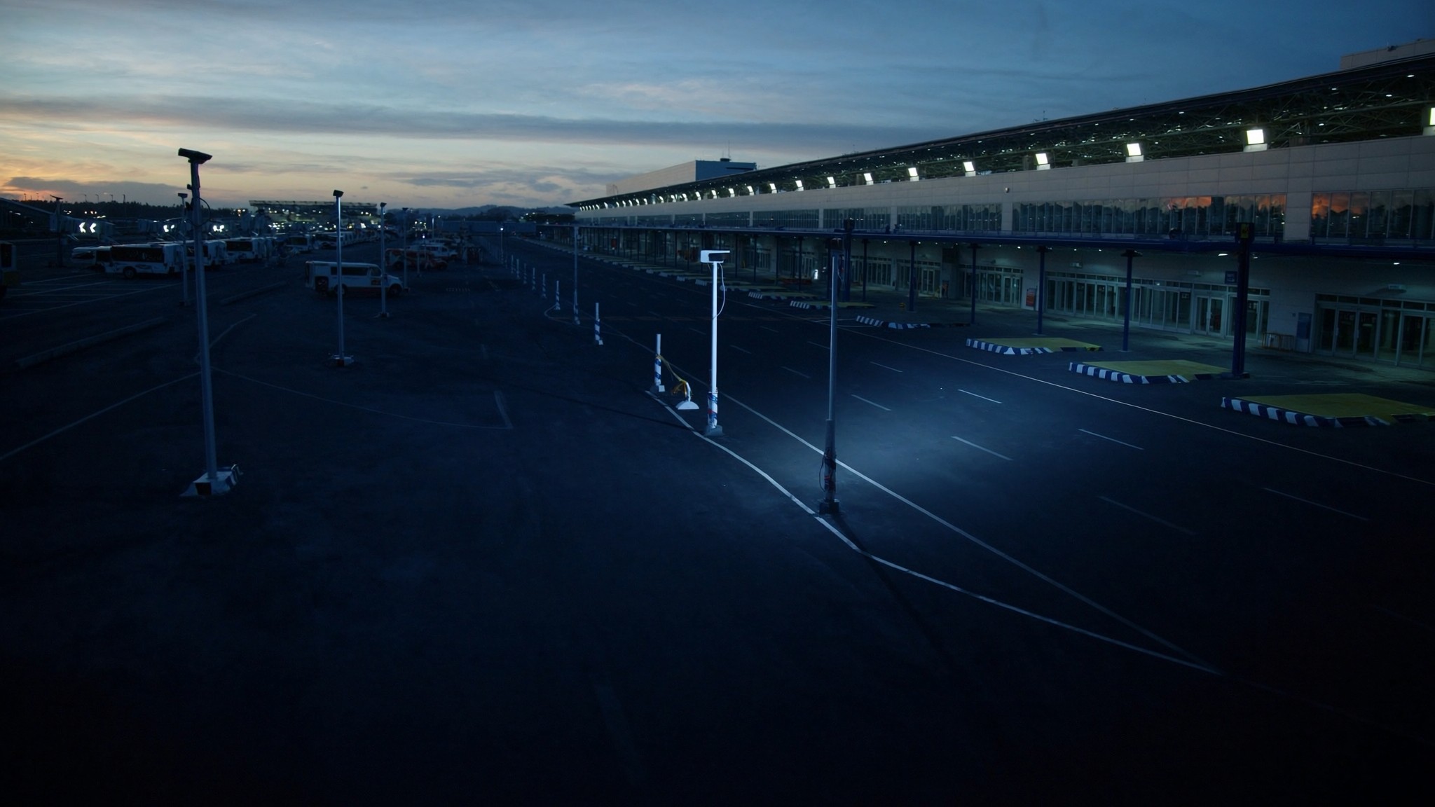Bus and ground transport lanes at a terminal with fixed capture infrastructure at dusk